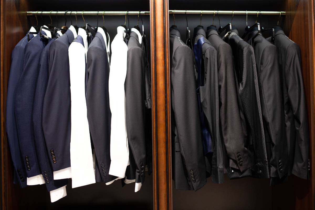 Staff presenting freshly cleaned blazer at dry cleaning shop