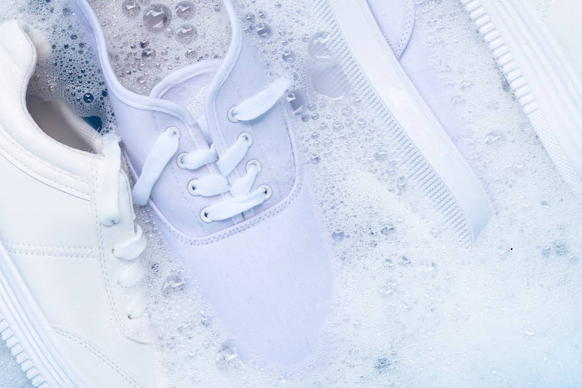 White sneakers soaking in water and soap for cleaning